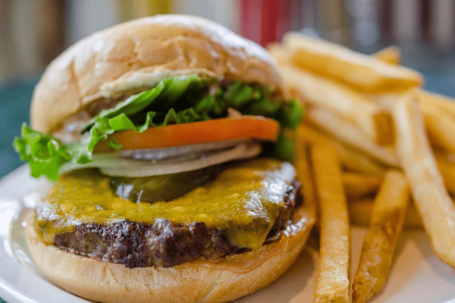 cheeseburger with pickles, onions, lettuce, and tomato served with fries